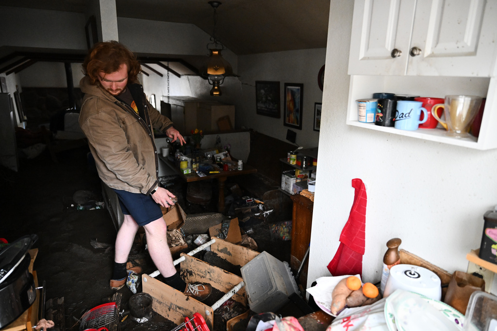 Davey Schneider recovers items from his storm-damaged home on Thursday, Dec. 25, 2025, in Wrightwood, Calif. (AP Photo/William Liang)