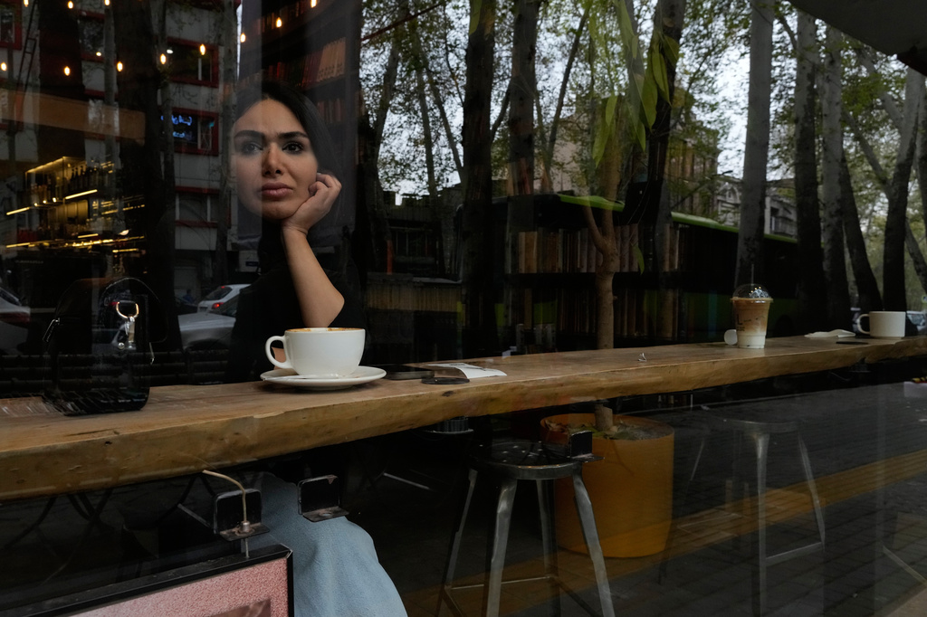 A women sits at a cafe in northern Tehran, Iran, Sunday, April 12, 2026. (AP Photo/Vahid Salemi)