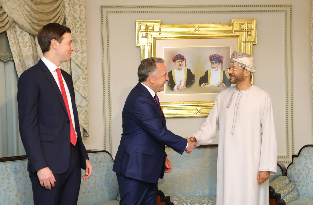 In this photo released by the Oman's Foreign Ministry, Steve Witkoff, White House special envoy, center, shakes hands with Oman's Foreign Minister Sayyid Badr Albusaidi as Jared Kushner, left, looks on during their meeting prior to Iran and the U.S. negotiations, in Muscat, Oman, Friday, Feb. 6, 2026. (Oman Foreign Ministry via AP)
