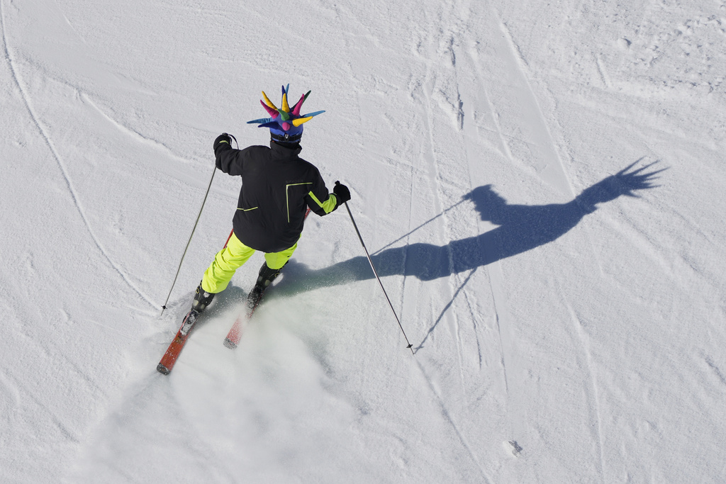 A skier wearing a colorful costume hat makes his way down a slope at the Mzaar-Kfardebian ski resort northeast of Beirut, Lebanon, Saturday, Jan. 3, 2026. (AP Photo/Hassan Ammar)