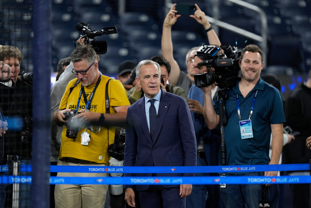 Canadian Prime Minister Mark Carney watches batting practice during a World Series baseball media day, Thursday, Oct. 23, 2025, in Toronto. The Toronto Blue Jays face the Los Angeles Dodgers in Game 1 on Friday. (AP Photo/David J. Phillip)