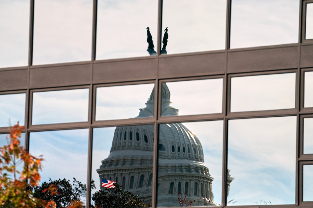 The Capitol dome is distorted by windows on the Teamsters' building, Tuesday, Nov. 4, 2025, in Washington. (AP Photo/Allison Robbert)