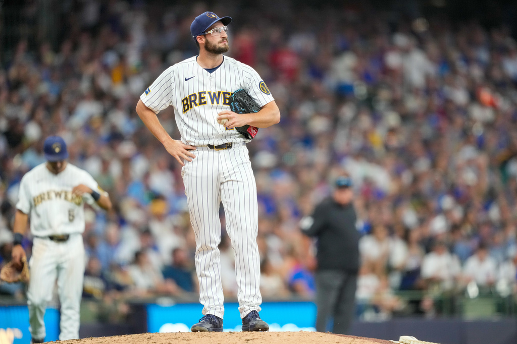 Milwaukee Brewers pitcher Aaron Ashby looks on as Milwaukee Brewers pitching coach Chris Hook approaches the mound to make a pitching change during the seventh inning of a baseball game against the Chicago Cubs, Sunday, June 28, 2026, in Milwaukee. (AP Photo/Kayla Wolf)