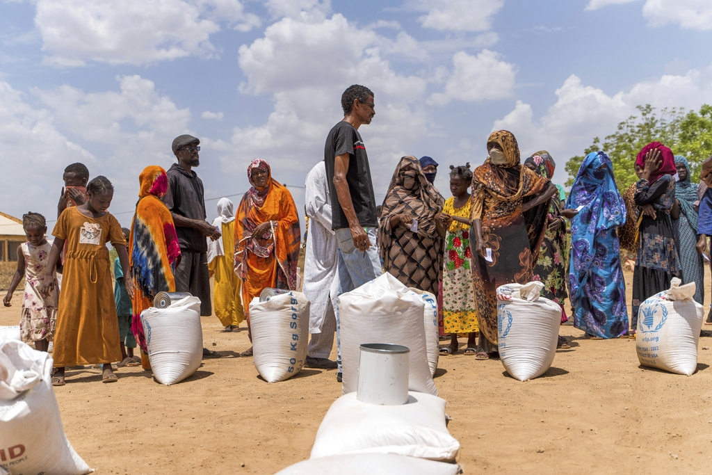 This June 2023 photo provided by the World Food Program shows food distribution by the WFP for internally displaced persons at the Wad Almajzoub farm camp in Wad Medani, Gezira state, Sudan. (Ala Kheir/U.N. Office for the Coordination of Humanitarian Affairs via AP)