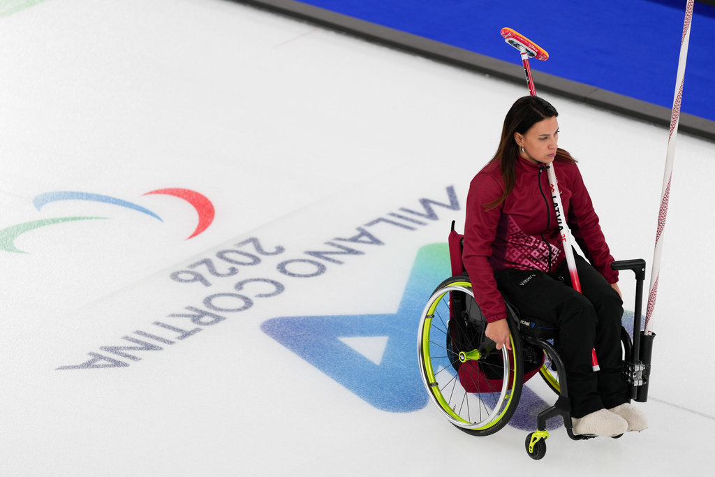 Polina Rozkova of Latvia, rides to the position during a wheelchair curling mixed doubles round robin session against Great Britain at the 2026 Winter Paralympics, in Cortina d'Ampezzo, Italy, Thursday, March 5, 2026. (AP Photo/Evgeniy Maloletka)