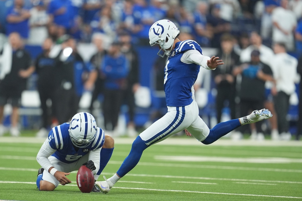 Indianapolis Colts kicker Spencer Shrader (3) kicks an extra point out of the hold of punter Rigoberto Sanchez during the first half of an NFL football game against the Las Vegas Raiders, Sunday, Oct. 5, 2025, in Indianapolis. (AP Photo/Michael Conroy)