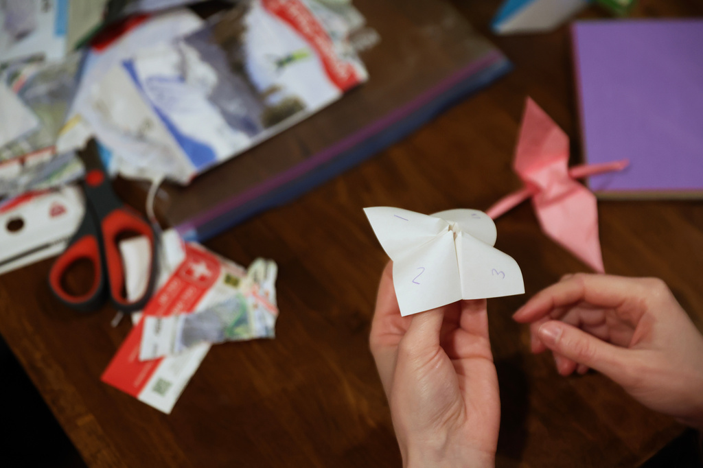 Guests play an origami game from the 90s during a weekly phone-free gathering at the home of organizer Dan Fox in the Brooklyn borough of New York, Wednesday, March 25, 2026. (AP Photo/Heather Khalifa)