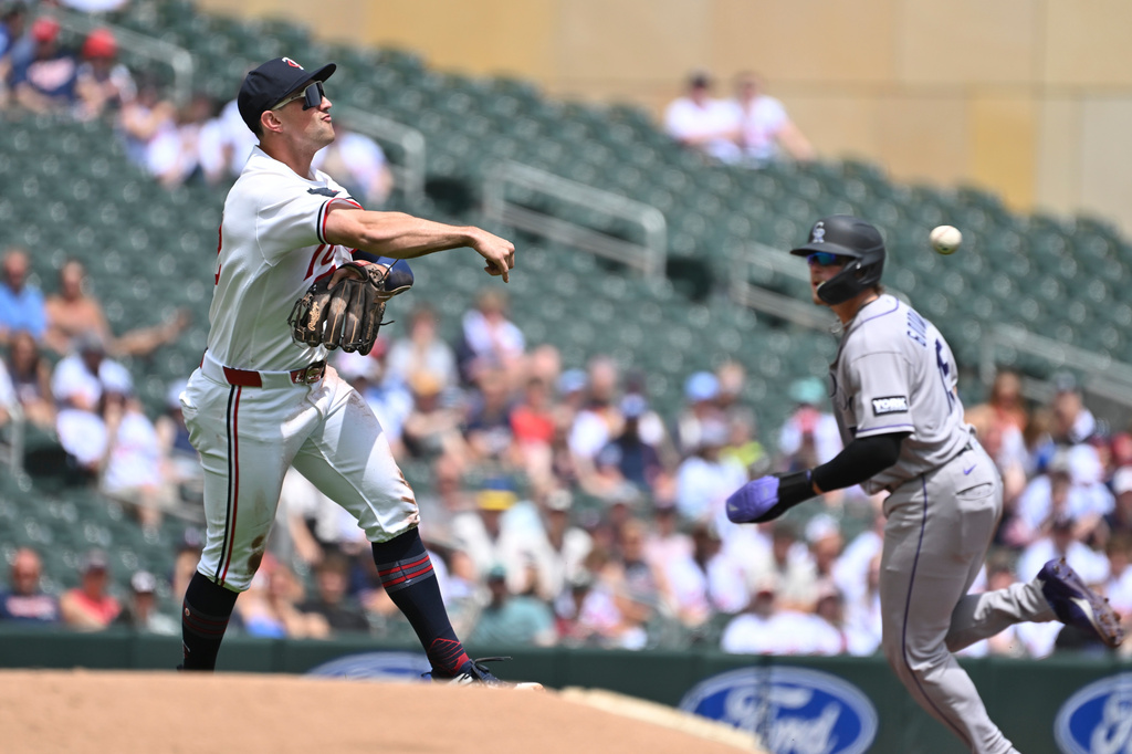 Minnesota Twins third baseman Brooks Lee, left, throws to second base for an out against the Colorado Rockies during the first inning of a baseball game Sunday, June 28, 2026, in Minneapolis. (AP Photo/Craig Lassig)