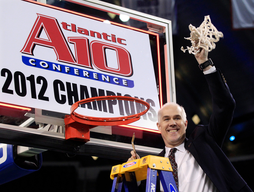 FILE - St. Bonaventure head coach Mark Schmidt waves the net that he cut down in celebration after defeating Xavier 67-56 to win the NCAA college basketball championship game in the Atlantic 10 men's tournament in Atlantic City, N.J., Sunday, March 11, 2012. (AP Photo/Mel Evans, File)