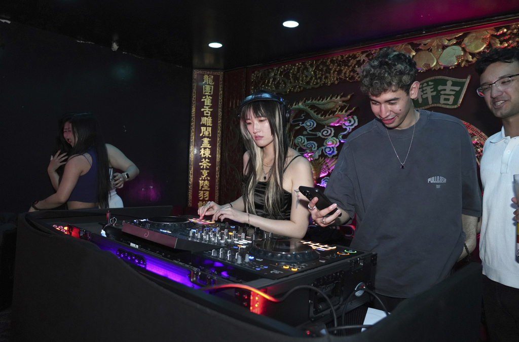 A DJ plays music at an event organized by the YLL Mahjong Club on Friday, Aug. 15, 2025, in San Francisco. (AP Photo/Terry Chea)