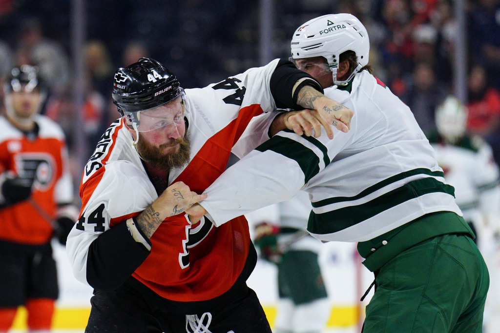 Philadelphia Flyers' Nicolas Deslauriers, left, and Minnesota Wild's Marcus Foligno, right, fight during the first period of an NHL hockey game, Saturday, Oct. 18, 2025, in Philadelphia. (AP Photo/Derik Hamilton)