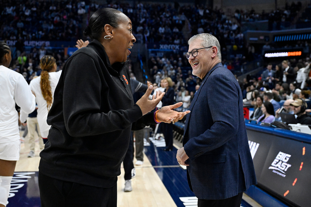 Syracuse head coach Felisha Legette-Jack, left, and UConn head coach Geno Auriemma share a light moment before the start of the second round of the NCAA college basketball tournament, Monday, March 23, 2026, in Storrs, Conn. (AP Photo/Jessica Hill)