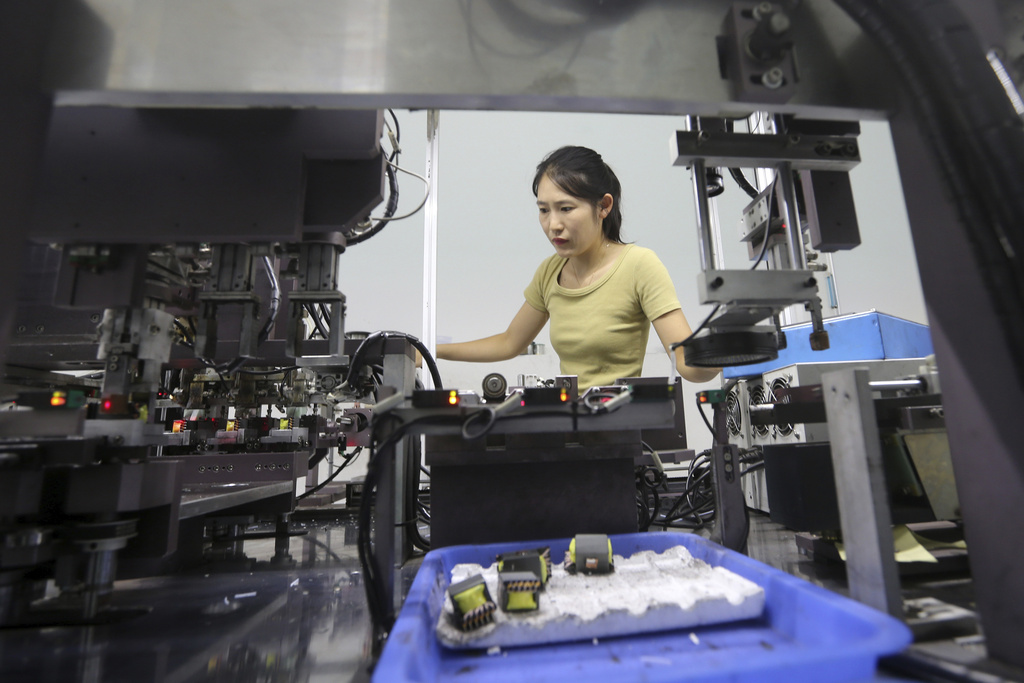 A woman works at an electronics factory in Suixi county in central China's Anhui province on Wednesday, Aug. 20, 2025. (Chinatopix via AP)