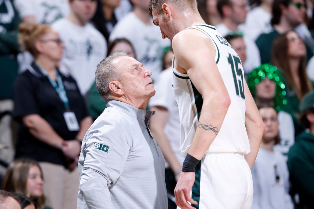 Michigan State coach Tom Izzo, left, talks with center Carson Cooper (15) during the first half of an NCAA college basketball game against Ohio State, Sunday, Feb. 22, 2026, in East Lansing, Mich. (AP Photo/Al Goldis)