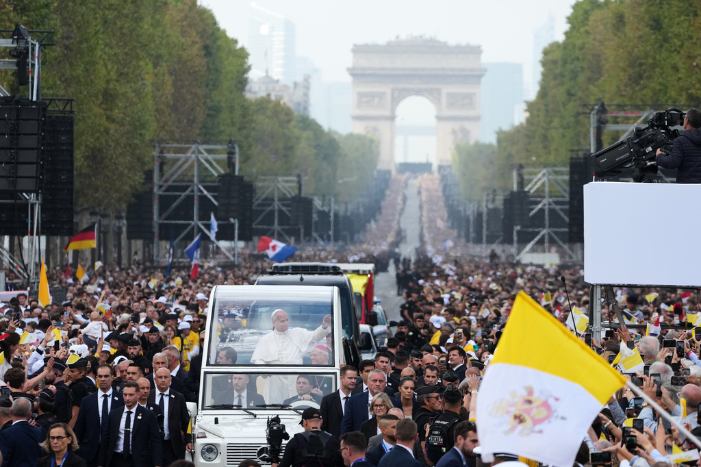 Pope Leo XIV, with the Arc de Triomphe in the background, waves from the popemobile as he arrives to celebrate Mass in Place de la Concorde in Paris, Saturday, Sept. 26, 2026. (AP Photo/Gregorio Borgia)