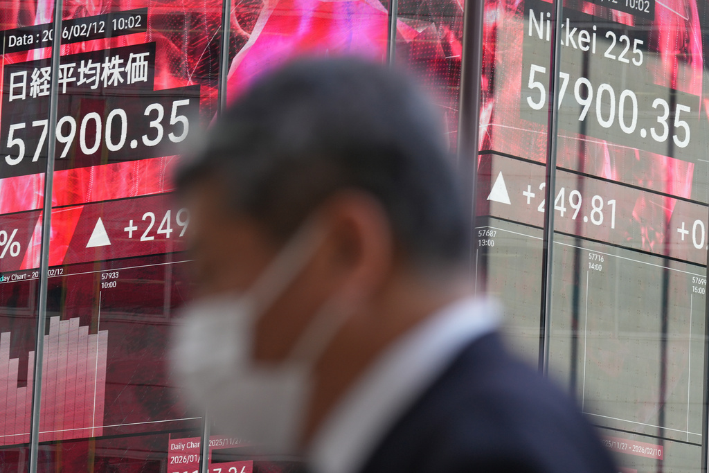 A person walks in front of an electronic stock board showing Japan's Nikkei index at a securities firm Thursday, Feb. 12, 2026, in Tokyo. (AP Photo/Eugene Hoshiko)
