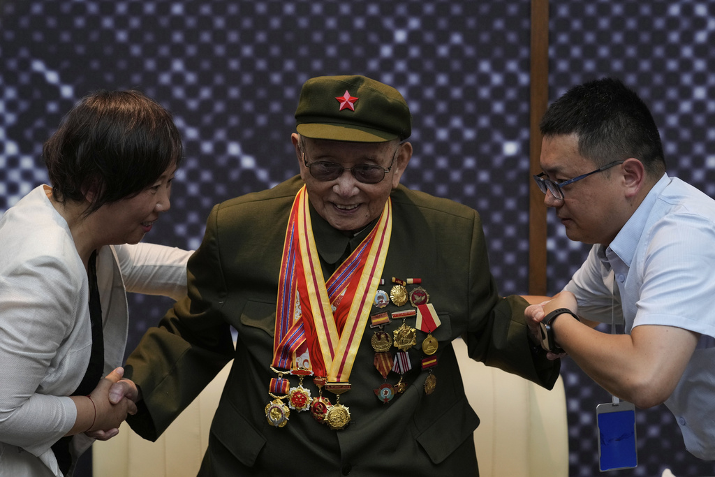 Yang Huafeng, a 92-year-old Chinese army veteran is helped as he meets reporters at the memorial of the September 18th History Museum in Shenyang, northeastern China's Liaoning province, Tuesday, Aug. 12, 2025. (AP Photo/Mahesh Kumar A.)