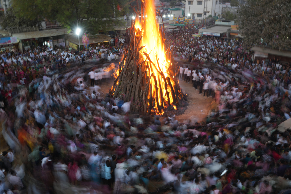 Indians perform rituals around a bonfire during Holi festival celebrations at Palaj village near Gandhinagar, India, Monday, March 2, 2026. (AP Photo/Ajit Solanki)