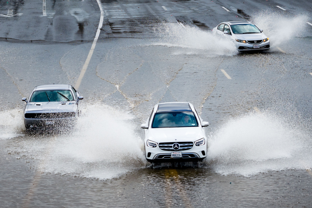 Cars drive on highway 101 flooded by the "King Tides", occurring when the sun, moon and Earth align, causing a stronger gravitational pull Saturday, Jan. 3, 2026, near Corte Madera in Marin County, Calif. (AP Photo/Ethan Swope)