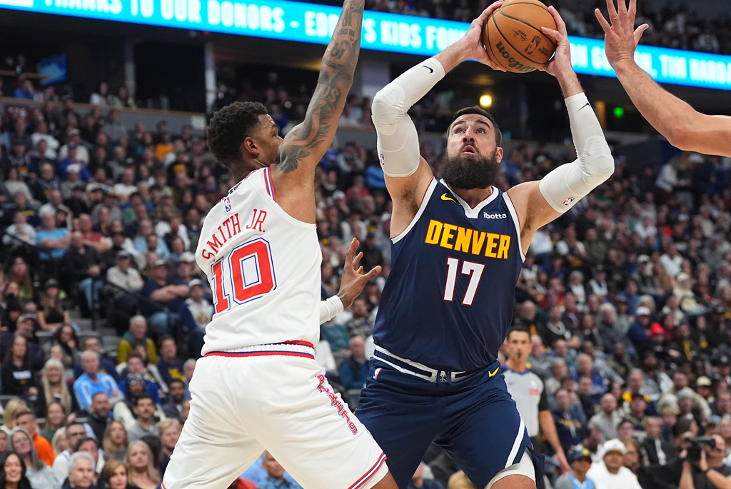 Denver Nuggets center Jonas Valančiūnas (17) goes up for a basket as Houston Rockets forward Jabari Smith Jr. (10) defends in the first half of an NBA basketball game Monday, Dec. 15, 2025, in Denver. (AP Photo/David Zalubowski)