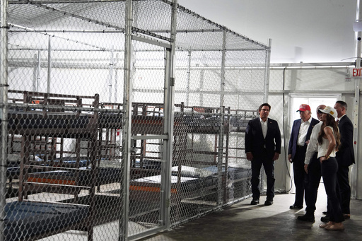 FILE - President Donald Trump, Gov. Ron DeSantis, R-Fla., and Homeland Security Secretary Kristi Noem, and others, tour "Alligator Alcatraz," a new migrant detention facility at Dade-Collier Training and Transition facility, Tuesday, July 1, 2025, in Ochopee, Fla. (AP Photo/Evan Vucci, File) FILE - President Donald Trump, Gov. Ron DeSantis, R-Fla., and Homeland Security Secretary Kristi Noem, and others, tour "Alligator Alcatraz," a new migrant detention facility at Dade-Collier Training and Transition facility, Tuesday, July 1, 2025, in Ochopee, Fla. (AP Photo/Evan Vucci, File)