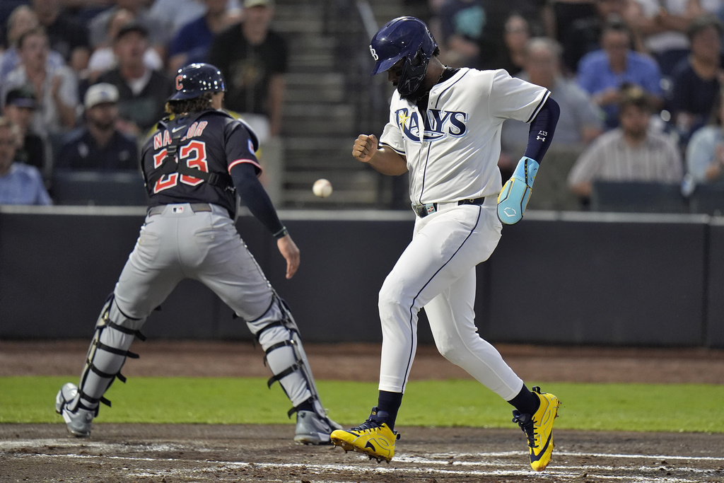 Tampa Bay Rays' Junior Caminero scores on an RBI single by Christopher Morel as the ball skips away from Cleveland Guardians catcher Bo Naylor during the first inning of a baseball game Thursday, Sept. 4, 2025, in Tampa, Fla. (AP Photo/Chris O'Meara)
