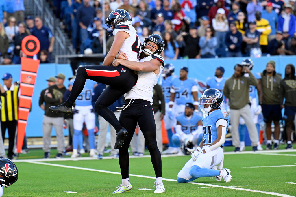 Houston Texans kicker Matthew Wright (42) is grabbed by Tommy Townsend after Wright kicked a 35-yard field goal as time expired in the fourth quarter to beat the Tennessee Titans 16-13 in an NFL football game on Sunday, Nov. 16, 2025, in Nashville, Tenn. (AP Photo/John Amis)