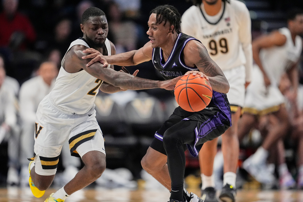 Vanderbilt guard Duke Miles (2) tries to steal the ball from Central Arkansas guard Luke Moore, right, during the first half of an NCAA college basketball game Saturday, Dec. 13, 2025, in Nashville, Tenn. (AP Photo/George Walker IV)