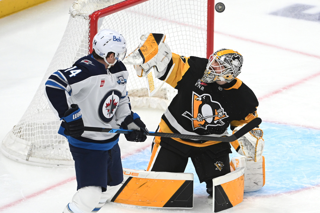 Pittsburgh Penguins goalie Arturs Silovs (37) makes a save under pressure from Winnipeg Jets right wing Gustav Nyquist (14) during the first period in an NHL hockey game, Saturday, March 21, 2026, in Pittsburgh. (AP Photo/Philip G. Pavely)