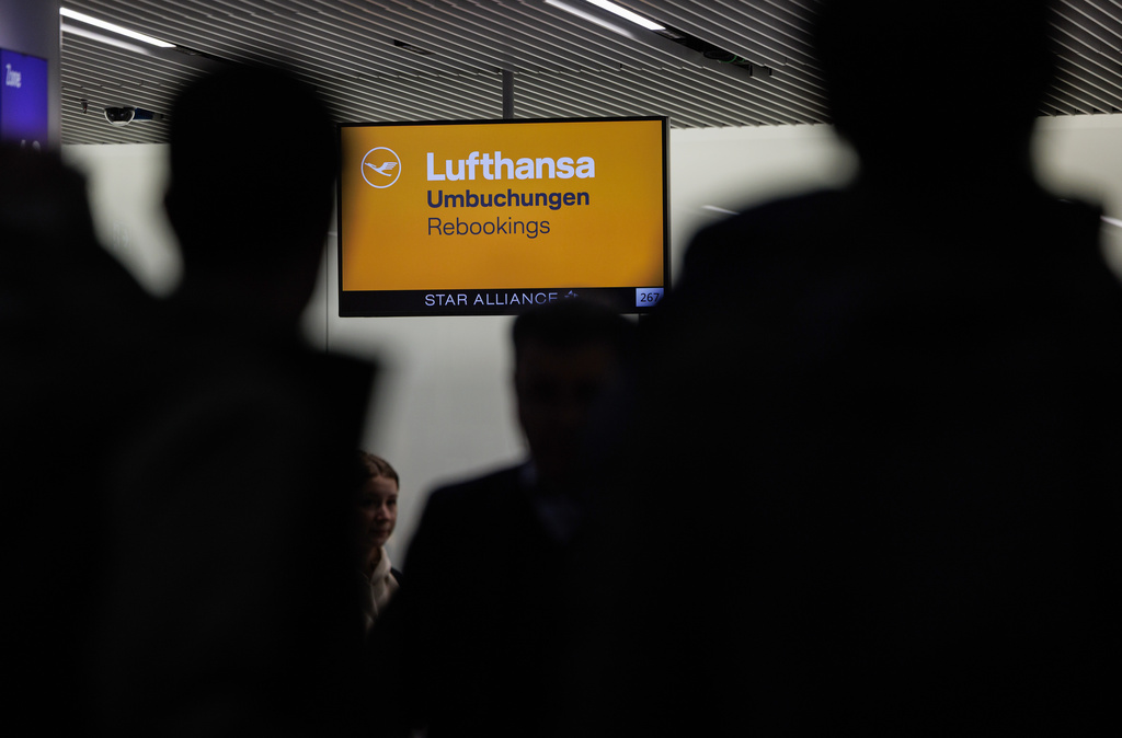 People stand in front of a Lufthansa service counter at Frankfurt Airport as a one-day strike by Lufthansa pilots and flight attendants begins on Thursday, Feb.12, 2026. ( Hannes P. Albert/dpa via AP)