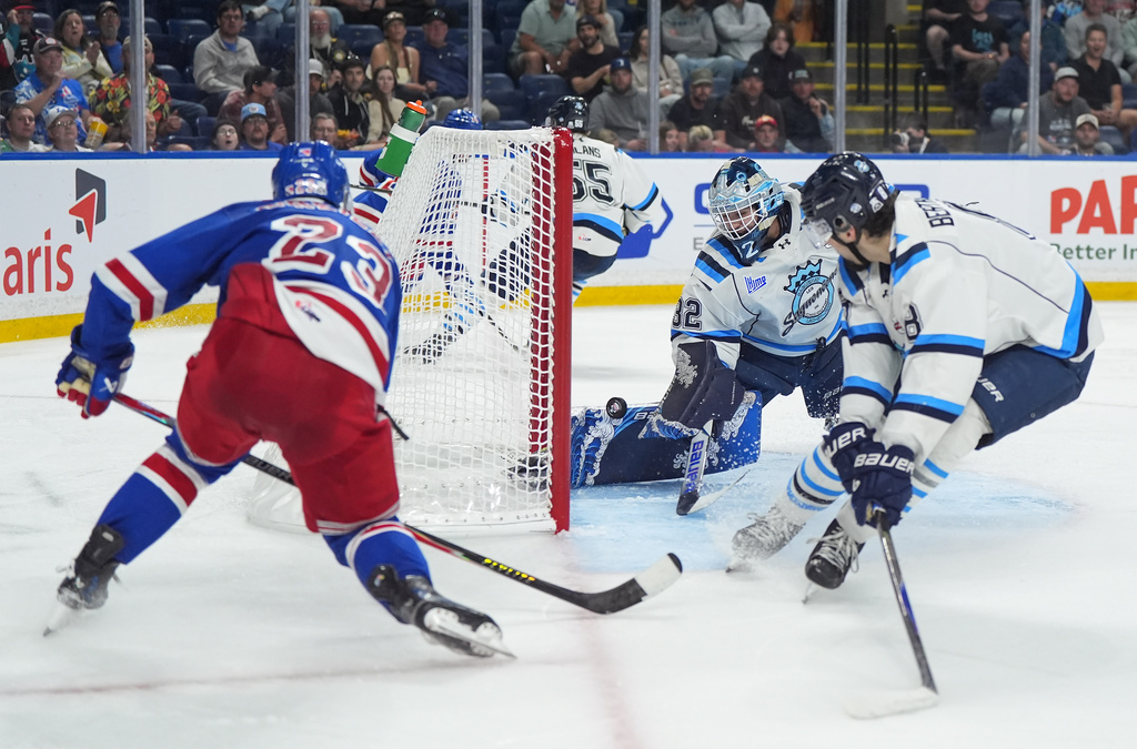 Kitchener Rangers' Sam O'Reilly (23) scores against Chicoutimi Sagueneens' goalie Lucas Beckman (32) as Christophe Berthelot (8) watches during the second period of a Memorial Cup hockey game, in Kelowna, B.C., on Tuesday, May 26, 2026. (Darryl Dyck/The Canadian Press via AP)