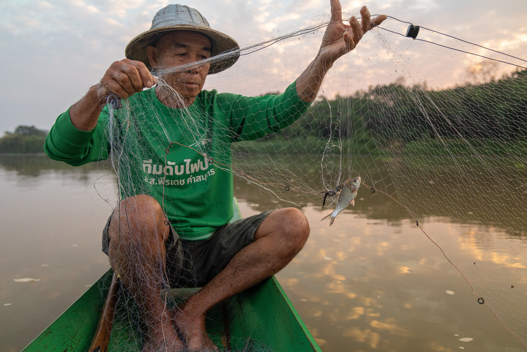Fisherman Sukjai Yana catches a small fish from the Kok River in Chiang Saen, Thailand, Sunday, Feb. 22, 2026. (AP Photo/Anton L. Delgado)