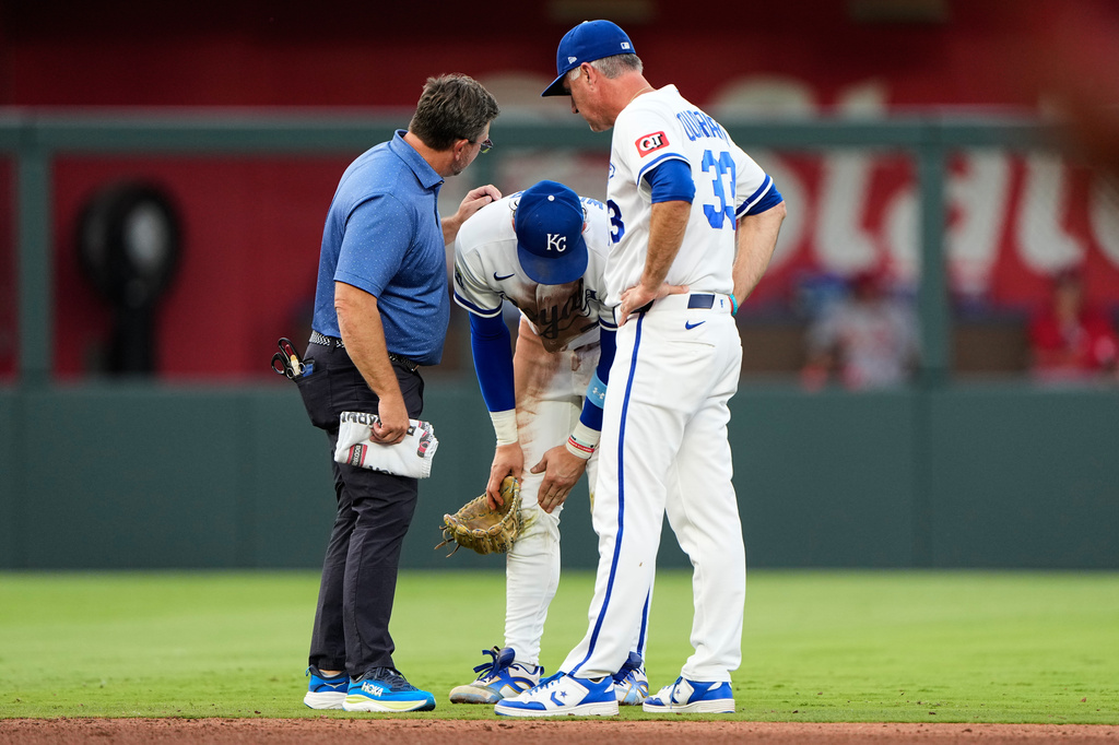 Kansas City Royals shortstop Bobby Witt Jr. talks to manager Matt Quatraro, right, and trainer Kyle Turner, left, after getting injured while fielding a single by St. Louis Cardinals' Jordan Walker during the fourth inning of a baseball game Thursday, June 18, 2026, in Kansas City, Mo. (AP Photo/Charlie Riedel)