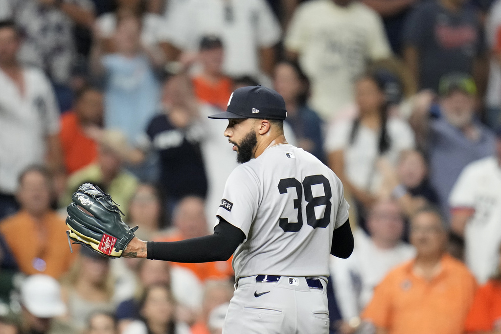New York Yankees relief pitcher Devin Williams (38) exchanges words with home plate umpire Brian Walsh as he walked back to the dugout after giving up a run walking Houston Astros' Taylor Trammell with the bases loaded during the eighth inning of a baseball game Wednesday, Sept. 3, 2025, in Houston. (AP Photo/Karen Warren)