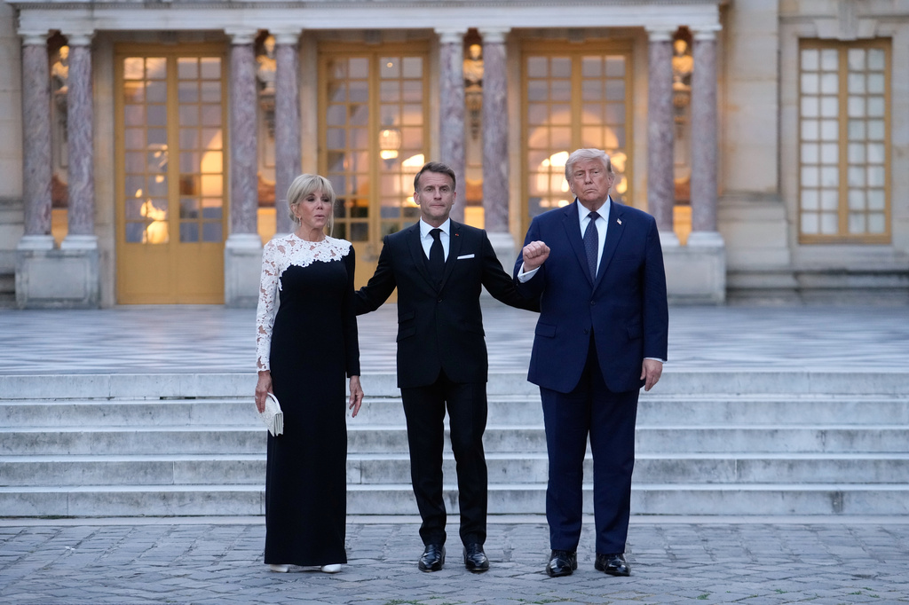 France's President Emmanuel Macron, center, his wife Brigitte, left, and U.S. President Donald Trump pose before a private dinner to celebrate the USA's 250th birthday, at the Palace of Versailles, outside Paris, Wednesday, June 17, 2026. (AP Photo/Michel Euler)