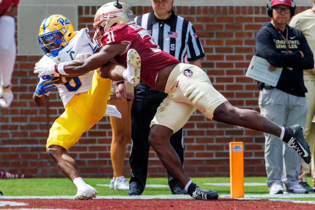 Pittsburgh running back Desmond Reid (0) catches a pass for his team's second touchdown as Florida State linebacker Elijah Herring (31) defends during the first half of an NCAA college football game, Saturday, Oct. 11, 2025, in Tallahassee, Fla. (AP Photo/Colin Hackley)