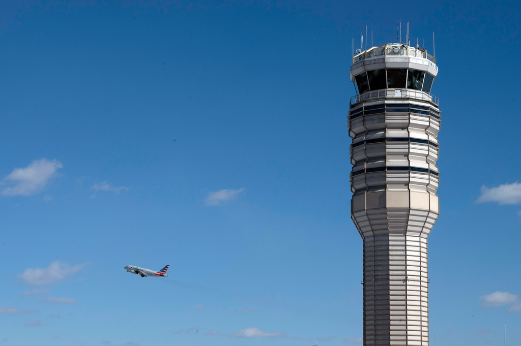 An airplane takes off behind the control tower at Ronald Reagan Washington National Airport, on the anniversary of the Potomac River mid-air collision between an American Airlines passenger plane and an Army Blackhawk helicopter, Thursday, Jan. 29, 2026, in Arlington, Va. (AP Photo/Cliff Owen)