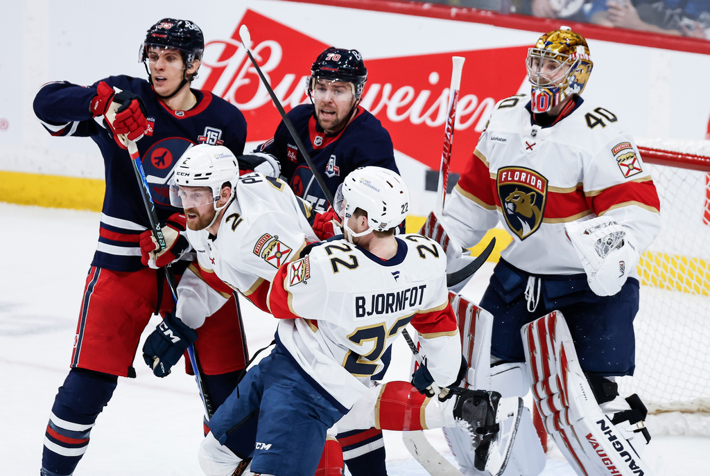 Florida Panthers' Jeff Petry (2) and Tobias Bjornfot (22) defend against Winnipeg Jets' Morgan Barron (36) and Tanner Pearson (70) during second-period NHL hockey game action in Winnipeg, Manitoba, Thursday, Jan. 22, 2026. (John Woods/The Canadian Press via AP)