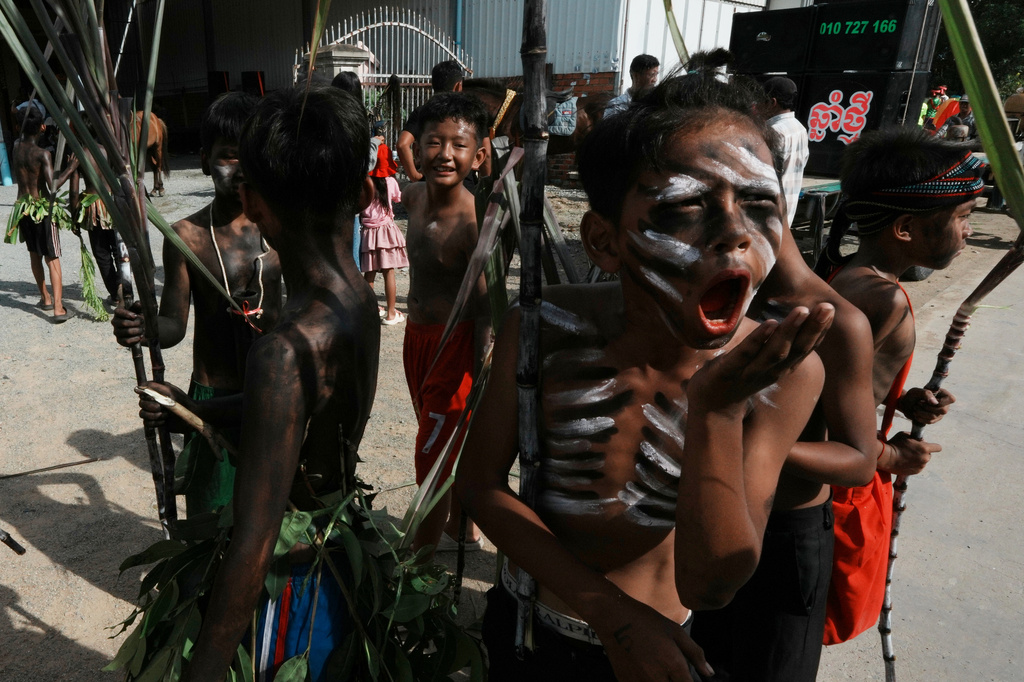 Boys representing ghosts participate during a ceremony to invoke rain amid the rice planting season in Pring Ka-ek village, northwest of Phnom Penh, Cambodia, Thursday, May 21, 2026. (AP Photo/Heng Sinith)