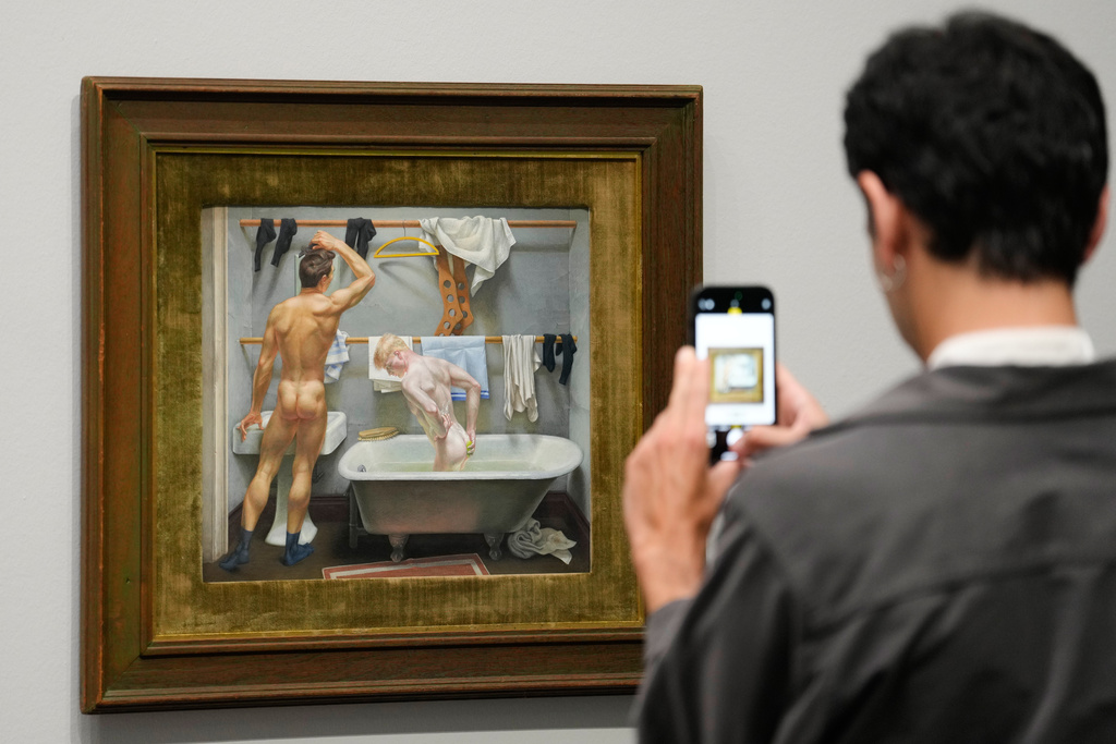 A man takes a photo of the artwork "The Bath" by artist Paul Cadmus at the new exhibition "Queer Modernism. 1900 to 1950" at the Kunstsammlung NRW museum in Duesseldorf, Germany, highlighting the contributions of queer artists to modernism. (AP Photo/Martin Meissner)