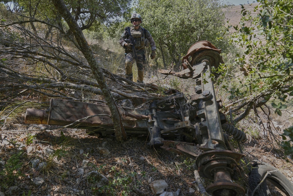 A French U.N. peacekeeper walks past a destroyed Hezbollah artillery cannon in the Saluki Valley, south Lebanon, Wednesday, Aug. 20, 2025. (AP Photo/Hussein Malla)