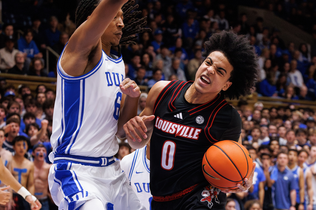 Louisville's Mikel Brown Jr. (0) drives as Duke's Maliq Brown (6) defends during the first half of an NCAA college basketball game in Durham, N.C., Monday, Jan. 26, 2026. (AP Photo/Ben McKeown)