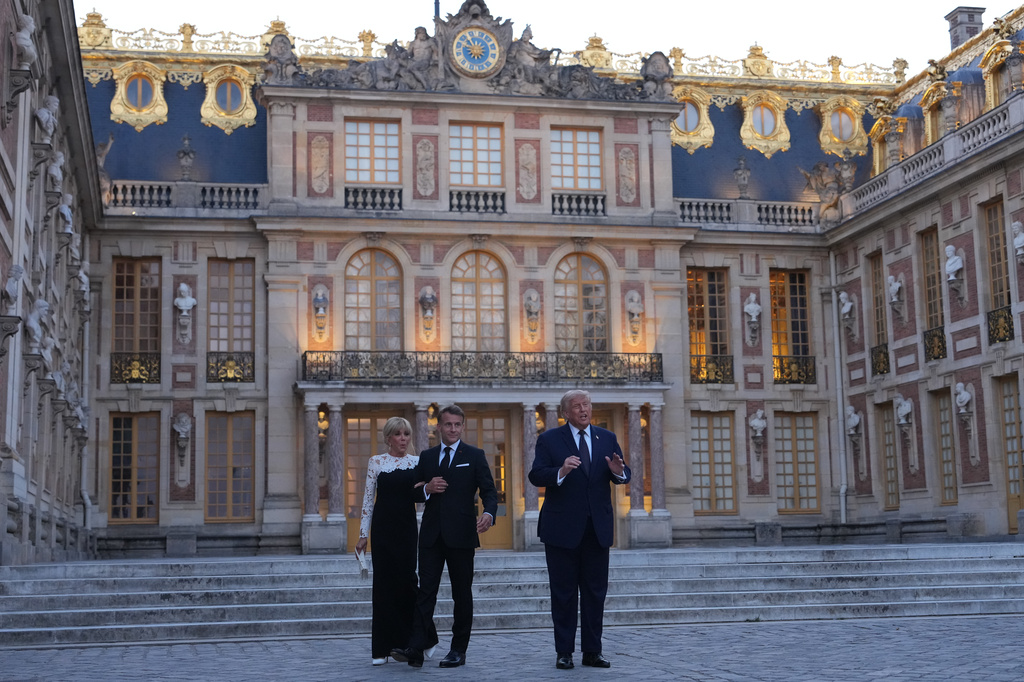 U.S. President Donald Trump is greeted by French President Emmanuel Macron and first lady Brigitte Macron as he arrives at the Palace of Versailles, Wednesday, June 17, 2026, in Versailles, France. (AP Photo/Julia Demaree Nikhinson)