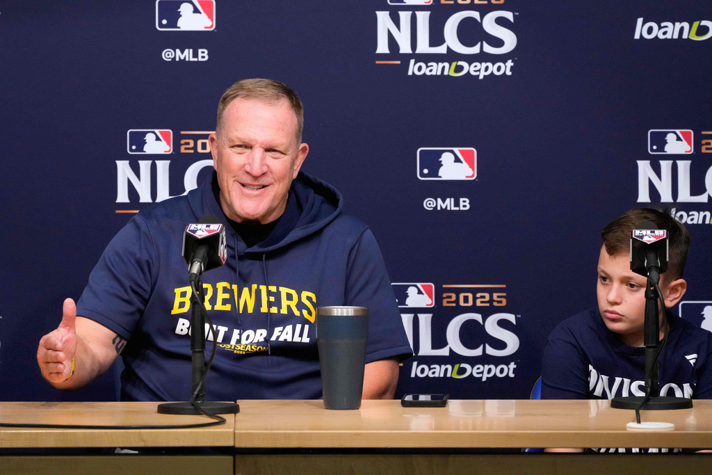 Milwaukee Brewers manager Pat Murphy speaks during a news conference as his son Austin sits with him ahead of Game 3 of baseball's National League Championship Series against the Los Angeles Dodgers, Wednesday, Oct. 15, 2025, in Los Angeles. (AP Photo/Mark J. Terrill)