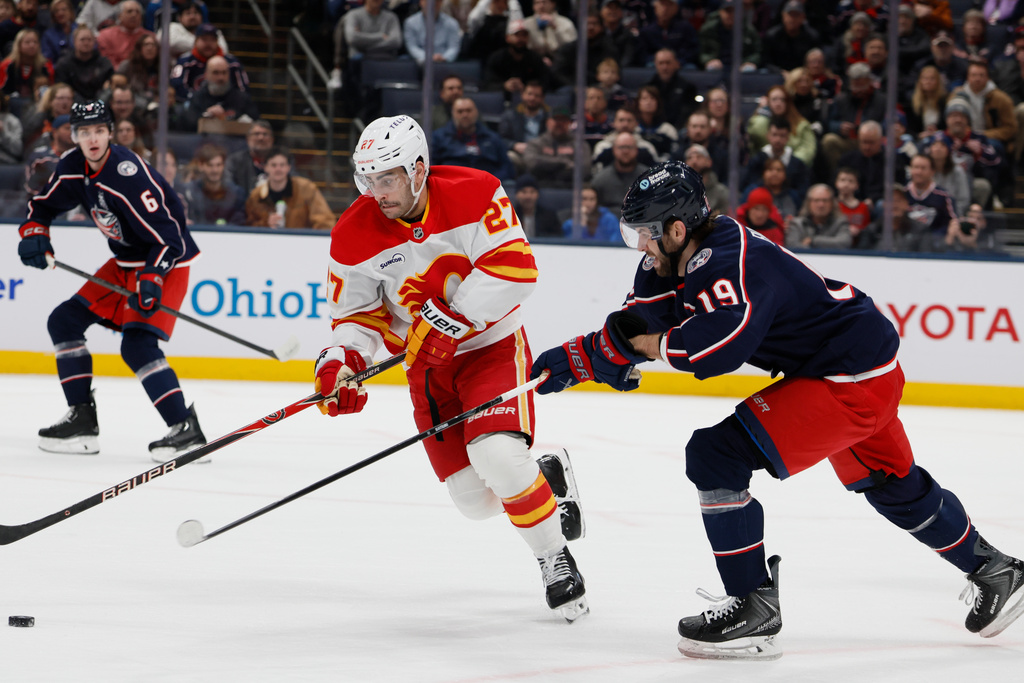 Calgary Flames' Matt Coronato, left, tries to skate past Columbus Blue Jackets' Adam Fantilli during the first period of an NHL hockey game, Tuesday, Jan. 13, 2026, in Columbus, Ohio. (AP Photo/Jay LaPrete)