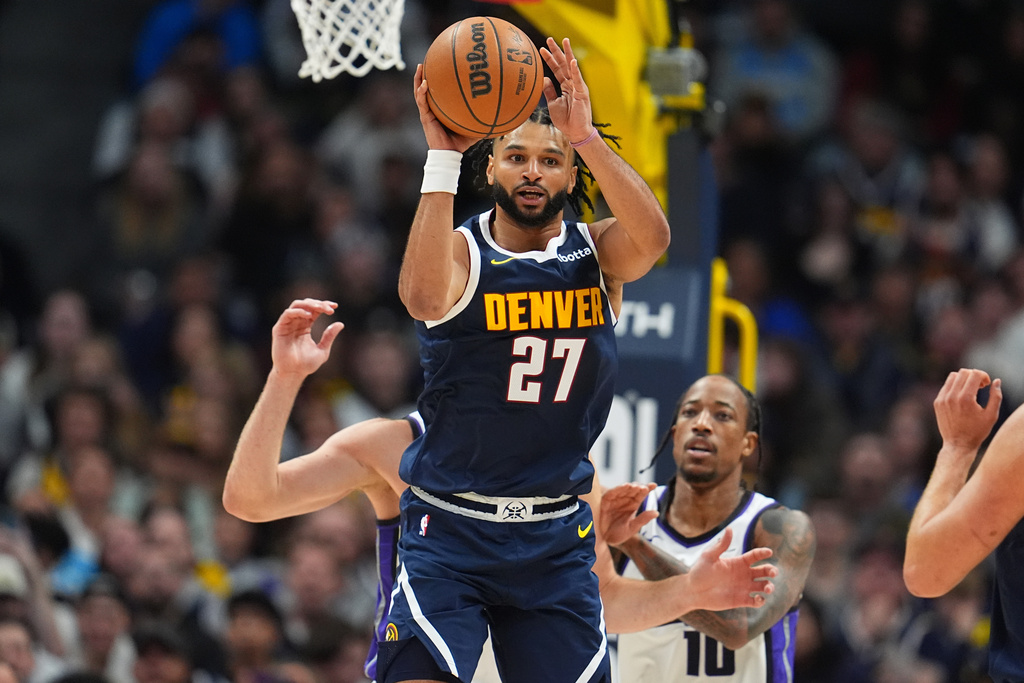 Denver Nuggets guard Jamal Murray, front, looks to pass the ball as Sacramento Kings forward Domantas Sabonis, back left, and guard DeMar DeRozan defend in the first half of an NBA basketball game Monday, Nov. 3, 2025, in Denver. (AP Photo/David Zalubowski)