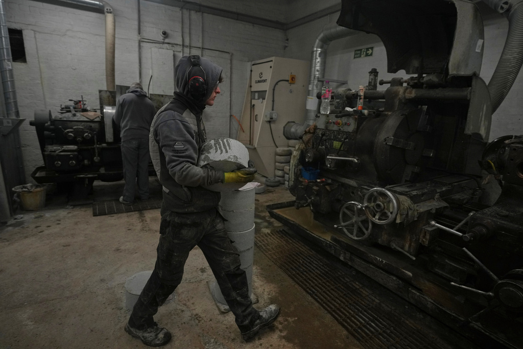 A craftsman carries a Common Green granite block to be machined into a curling stone at Kays Curling stone factory in Mauchline, Scotland, Tuesday, Nov. 11, 2025. (AP Photo/Alastair Grant)