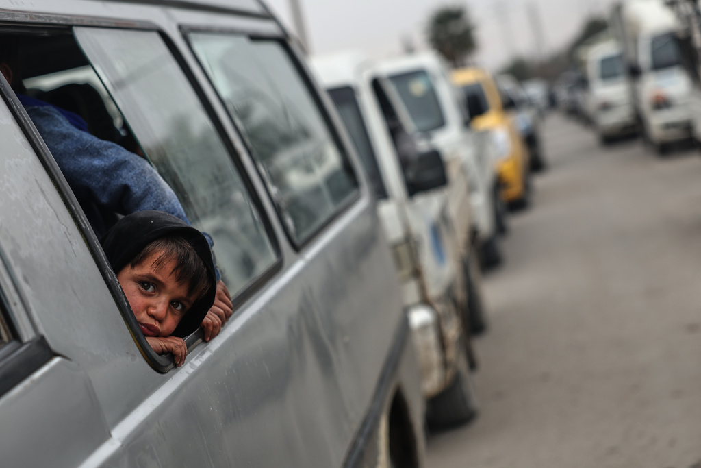 People cross a damaged bridge over the Euphrates River in Deir Ezzor, eastern Syria, after Syrian government forces took control of the area following the withdrawal of Kurdish-led Syrian Democratic Forces (SDF), Thursday, Jan. 22, 2026. (AP Photo/Ghaith Alsayed)