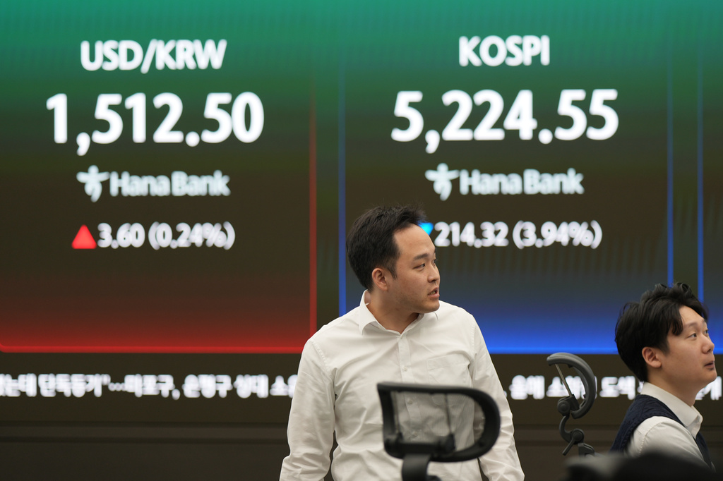 Dealers work near the screens showing the Korea Composite Stock Price Index (KOSPI), right, and the foreign exchange rate between U.S. dollar and South Korean won at a dealing room of Hana Bank in Seoul, South Korea, Monday, March 30, 2026. (AP Photo/Lee Jin-man)