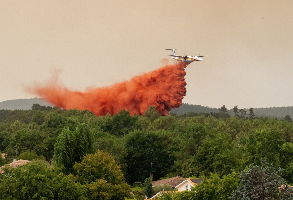 A water bomber drops water while fighting wildfires in the Lège-Cap-Ferret region, western France, Thursday, July 23, 2026. (AP Photo/Caroline Blumberg)